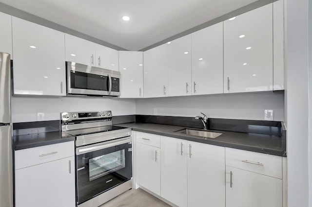 kitchen featuring sink, white cabinets, and appliances with stainless steel finishes