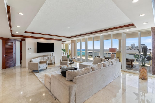 living room featuring a textured ceiling, floor to ceiling windows, a raised ceiling, and crown molding