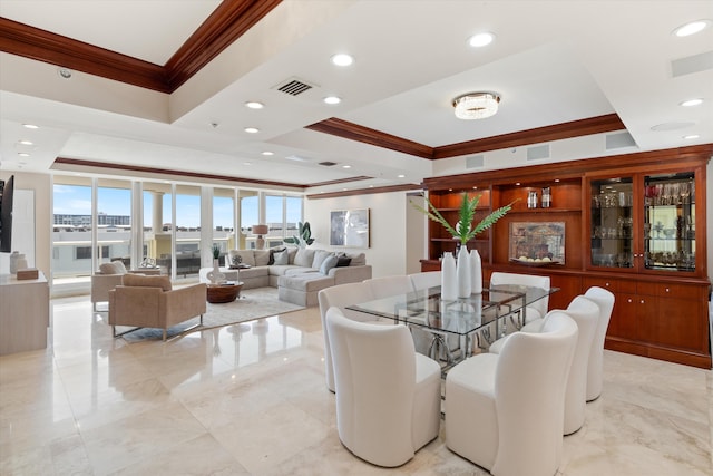 dining space with a raised ceiling, crown molding, and expansive windows