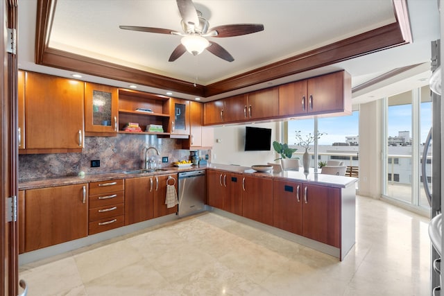 kitchen featuring ceiling fan, sink, tasteful backsplash, stainless steel dishwasher, and a tray ceiling