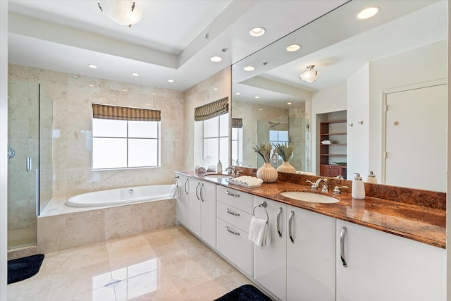 bathroom featuring plus walk in shower, vanity, and a tray ceiling