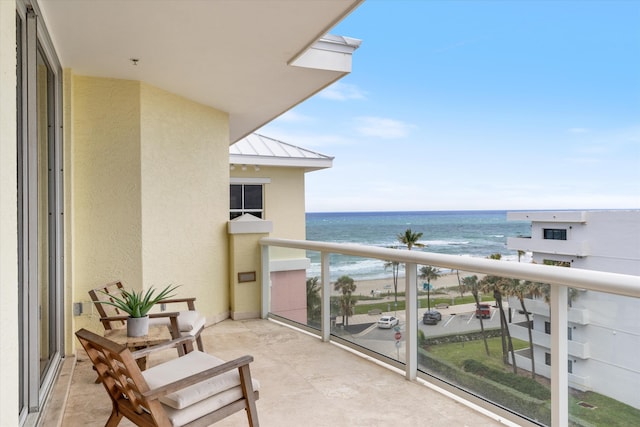 balcony with a water view and a beach view