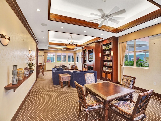 dining area featuring a raised ceiling, a wealth of natural light, and light colored carpet