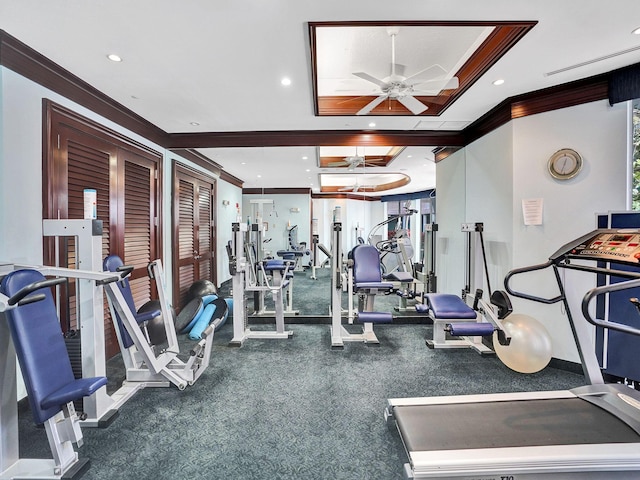 exercise room with ceiling fan, a raised ceiling, and ornamental molding