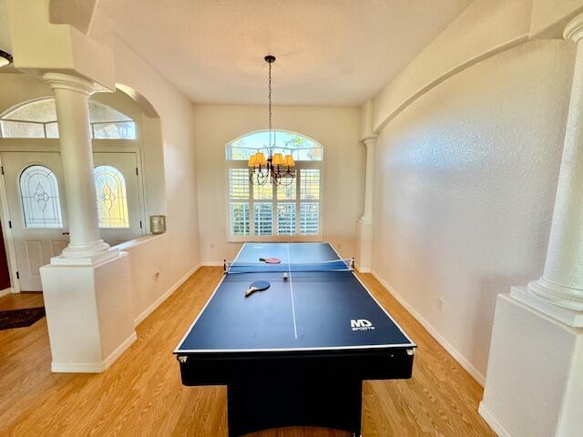 recreation room featuring light hardwood / wood-style flooring and a notable chandelier