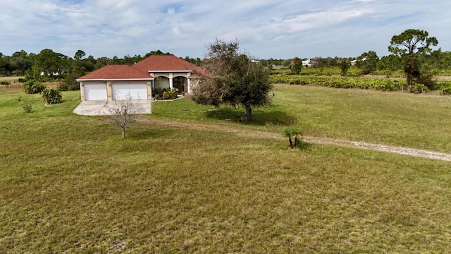 view of yard featuring a rural view and a garage