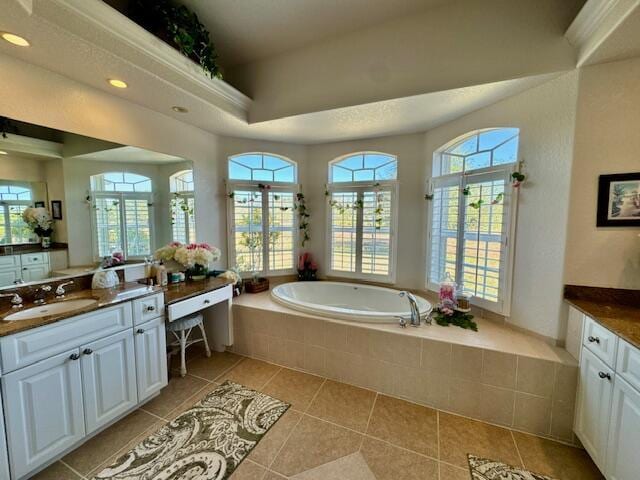 bathroom featuring tile patterned flooring, vanity, and tiled tub