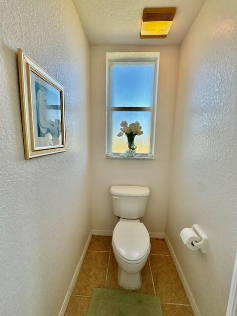 bathroom featuring tile patterned flooring, a textured ceiling, and toilet