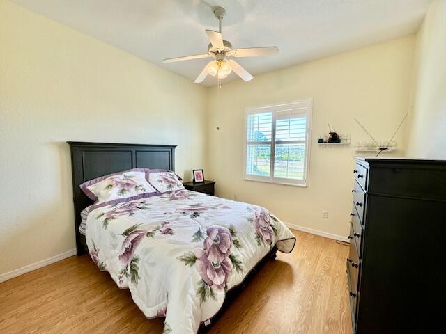 bedroom with ceiling fan and hardwood / wood-style floors