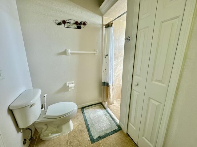 bathroom featuring tile patterned floors, toilet, and curtained shower