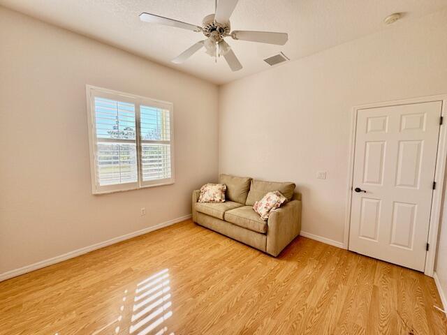 living area with ceiling fan and light wood-type flooring