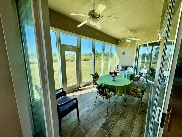 sunroom / solarium featuring ceiling fan