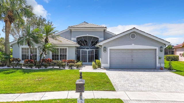 mediterranean / spanish-style home featuring a front yard and a garage