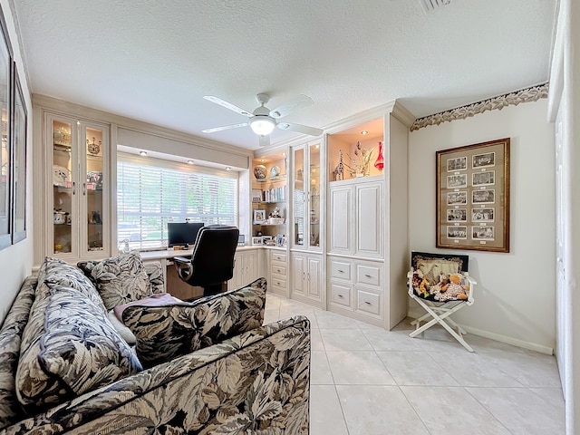 tiled office space featuring ceiling fan and a textured ceiling