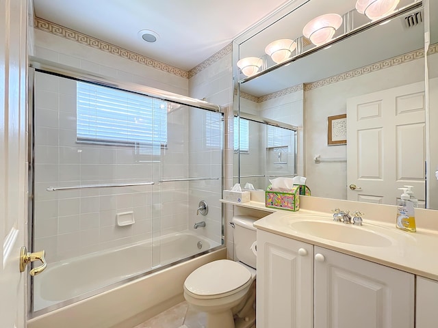 full bathroom featuring shower / bath combination with glass door, vanity, and toilet