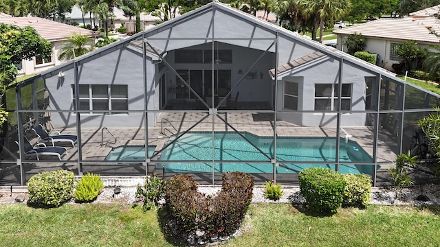 view of pool with glass enclosure and a patio area