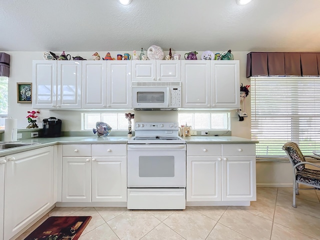 kitchen featuring white cabinetry, light tile patterned floors, and white appliances