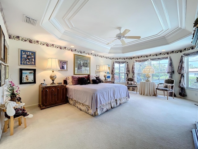 bedroom with ceiling fan, carpet floors, crown molding, and a tray ceiling