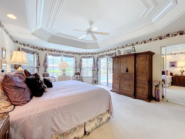 carpeted bedroom with a raised ceiling, access to exterior, ceiling fan, and ornamental molding