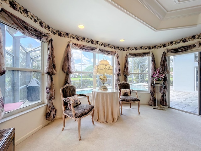 sitting room with carpet flooring, a raised ceiling, and crown molding