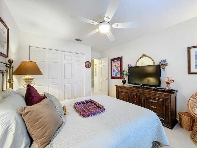 carpeted bedroom with ceiling fan and a closet