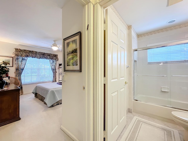 interior space with shower / bath combination with glass door, toilet, and ceiling fan