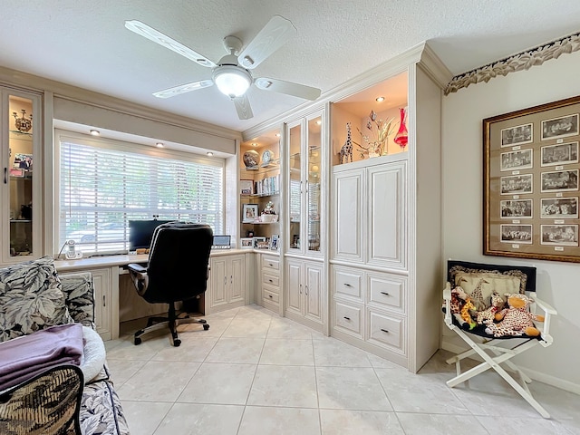 home office with a textured ceiling, ceiling fan, light tile patterned flooring, and crown molding