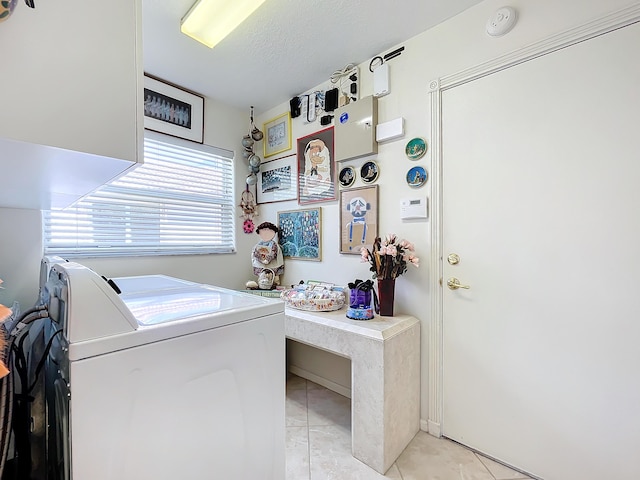 laundry room with washer and dryer, light tile patterned floors, and a textured ceiling