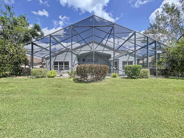 rear view of house with a lanai and a yard