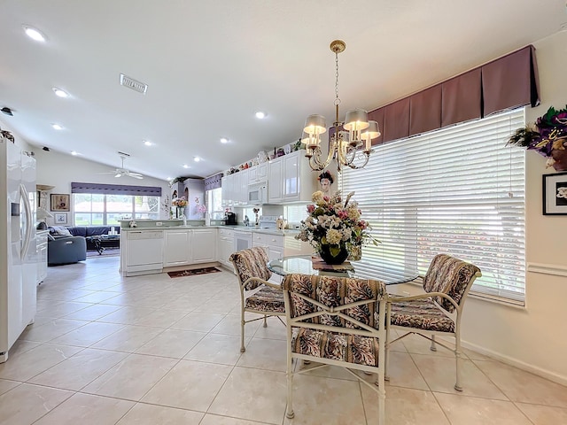 dining space featuring light tile patterned floors, ceiling fan with notable chandelier, and lofted ceiling