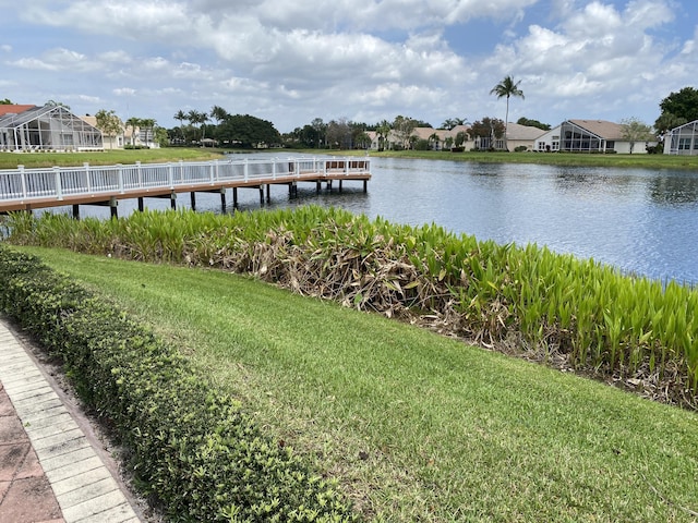 view of dock featuring a water view and a lawn