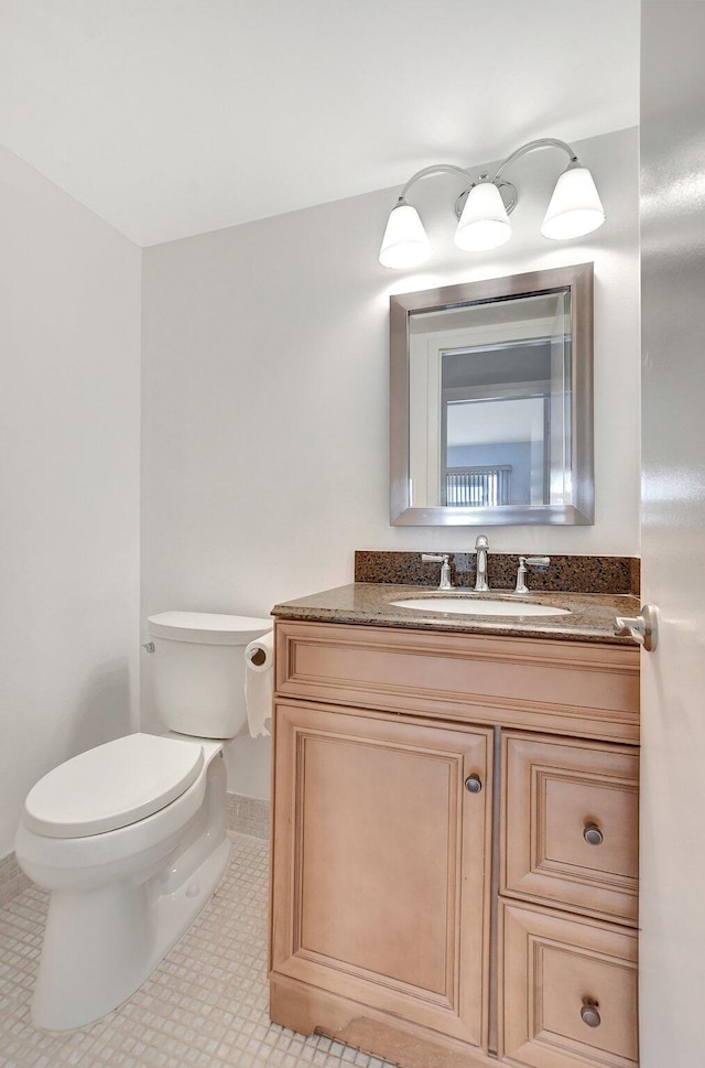 bathroom featuring tile patterned flooring, vanity, and toilet