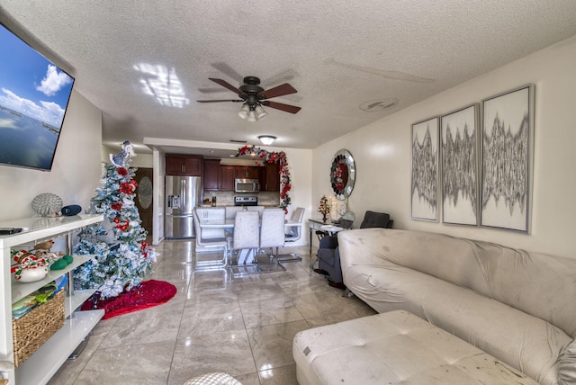 living room with ceiling fan and a textured ceiling