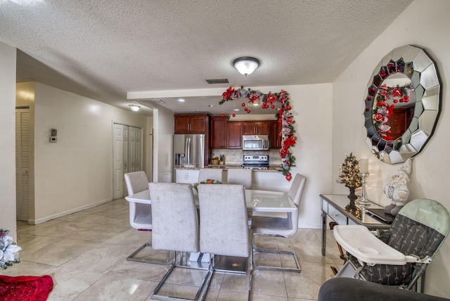 tiled dining area with a textured ceiling