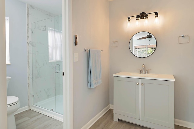 bathroom featuring vanity, toilet, a shower with door, and hardwood / wood-style floors