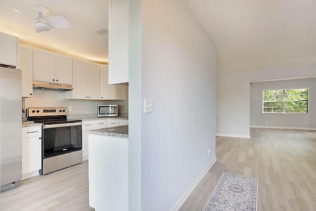 kitchen featuring appliances with stainless steel finishes, light wood-type flooring, white cabinets, and light stone counters