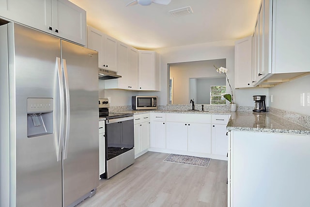 kitchen featuring light stone counters, appliances with stainless steel finishes, sink, and white cabinets