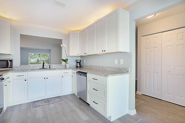 kitchen featuring stainless steel appliances, white cabinetry, sink, and light hardwood / wood-style floors