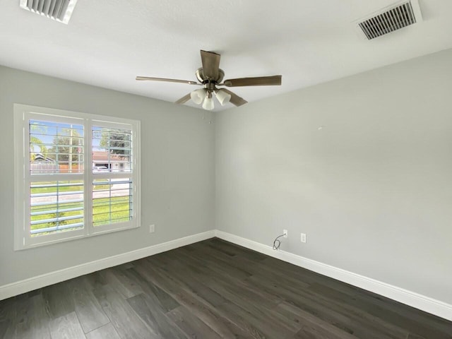 spare room with a wealth of natural light, ceiling fan, and dark wood-type flooring