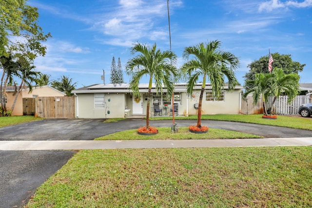 single story home with solar panels and a front yard