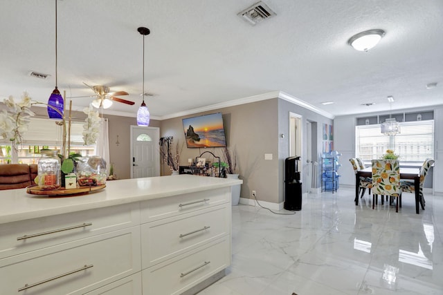 kitchen with decorative light fixtures, ceiling fan, white cabinetry, and a textured ceiling