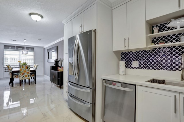 kitchen with white cabinetry, sink, hanging light fixtures, crown molding, and appliances with stainless steel finishes