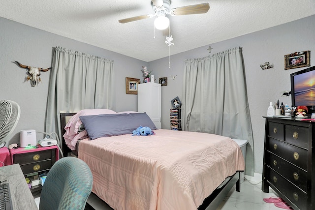 bedroom featuring ceiling fan and a textured ceiling