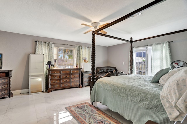 bedroom featuring access to exterior, a textured ceiling, and ceiling fan