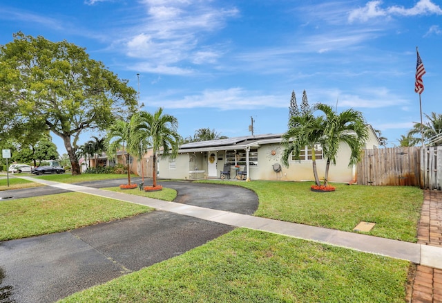 single story home featuring solar panels and a front yard