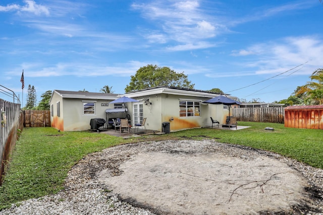 back of house with a yard and a patio area