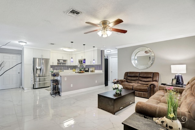 living room featuring ceiling fan, crown molding, and a textured ceiling