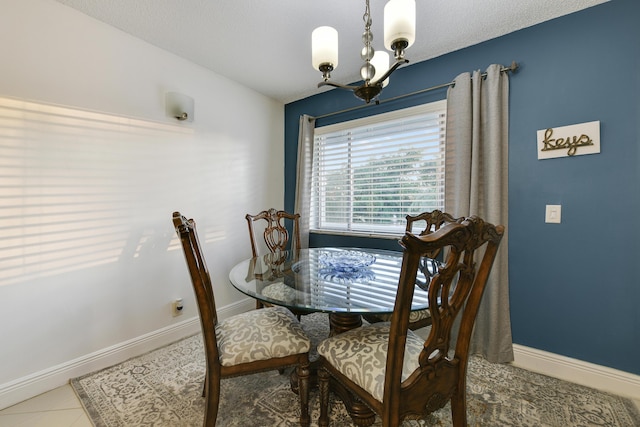 dining space with tile patterned floors and a notable chandelier