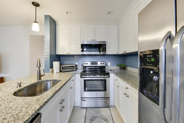 kitchen with white cabinets, appliances with stainless steel finishes, decorative light fixtures, and sink