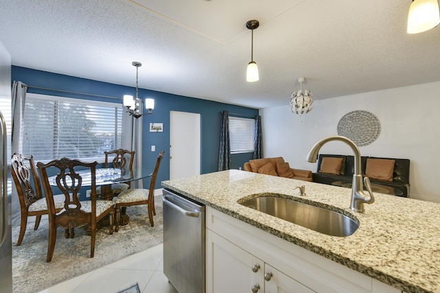 kitchen featuring white cabinetry, dishwasher, and decorative light fixtures